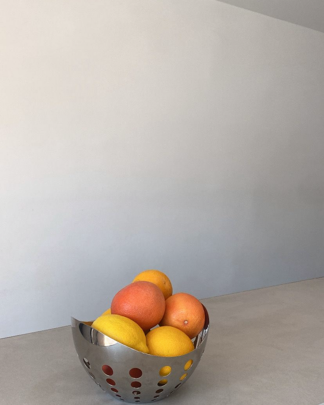 Frutero con naranjas y limones sobre la barra