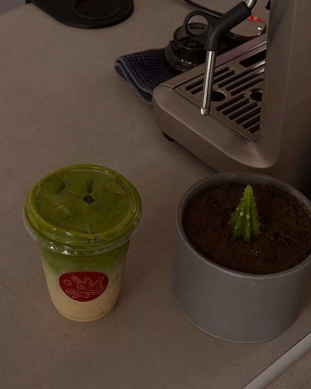 Matcha latte para llevar junto a la máquina de espresso