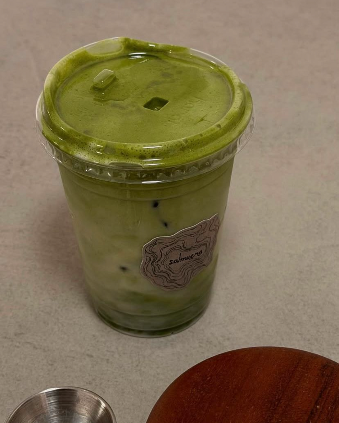 Matcha latte frío para llevar con el sticker de Salmuera